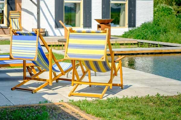 Ligstoelen op het terras aan de zwemvijver