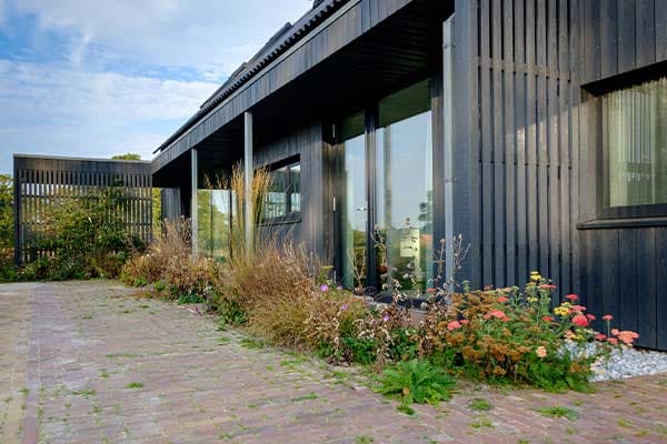 Terras van klinkers langs de gevel, met beplanting
