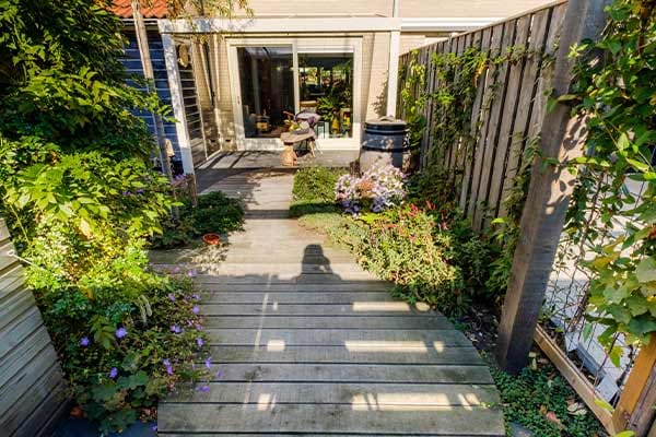 Pad van eiken planken langs de schutting naar het huis