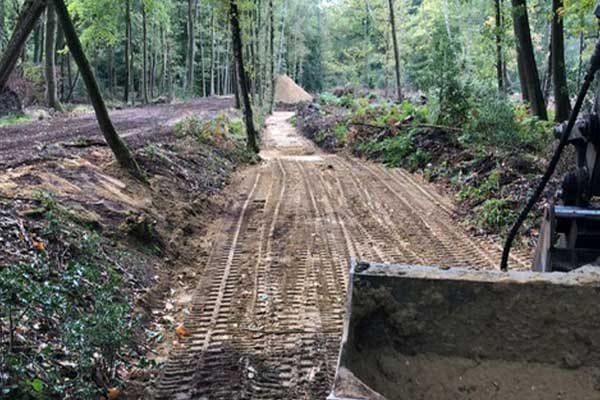 Uitgegraven watergang met rupssporen in het bos